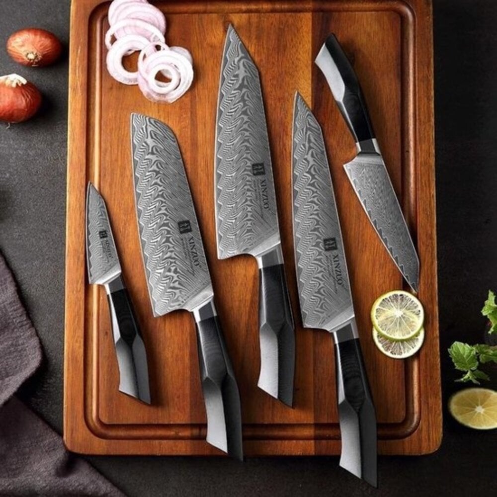 Close-up van een XinZuo B32 Feng Series mes met gehamerd 67-laags Damascus lemmet en ergonomisch G10 handvat met klinknagel; zichtbaar damascuspatroon, ±15° snijhoek en uitgebalanceerde, premium afwerking.