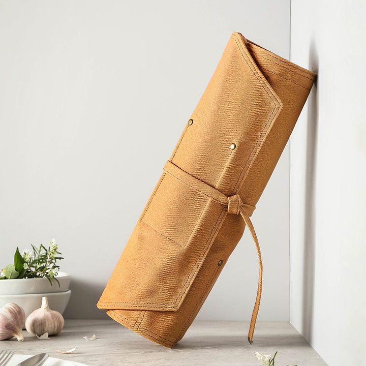 Opgerolde khaki messentas van canvas met strik tegen lichte achtergrond