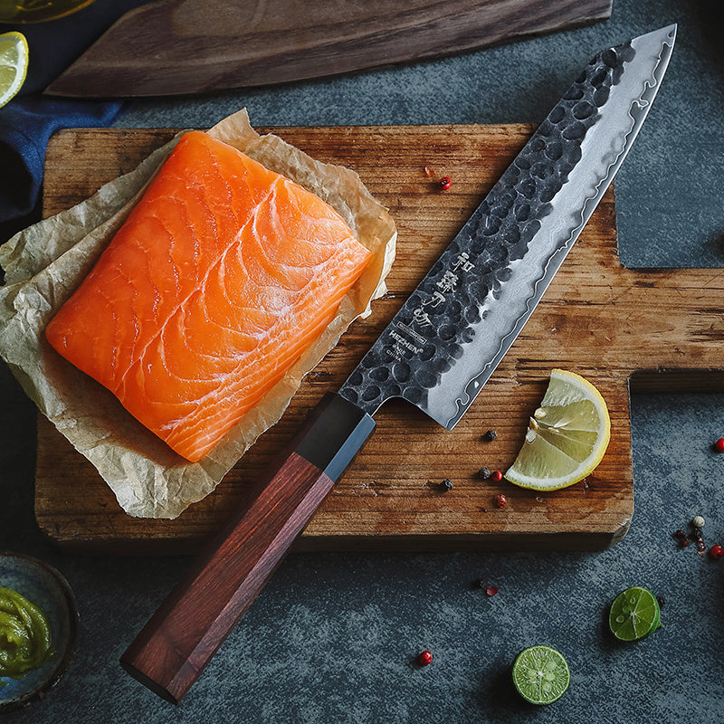 Hezhen PM8S damascus fileermes naast zalm op snijplank