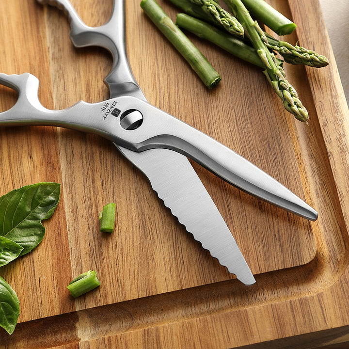 RVS keukenschaar op snijplank met asperges en basilicum