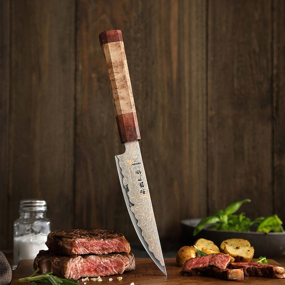 Hezhen X05C steakmes naast bord met steak en aardappelen