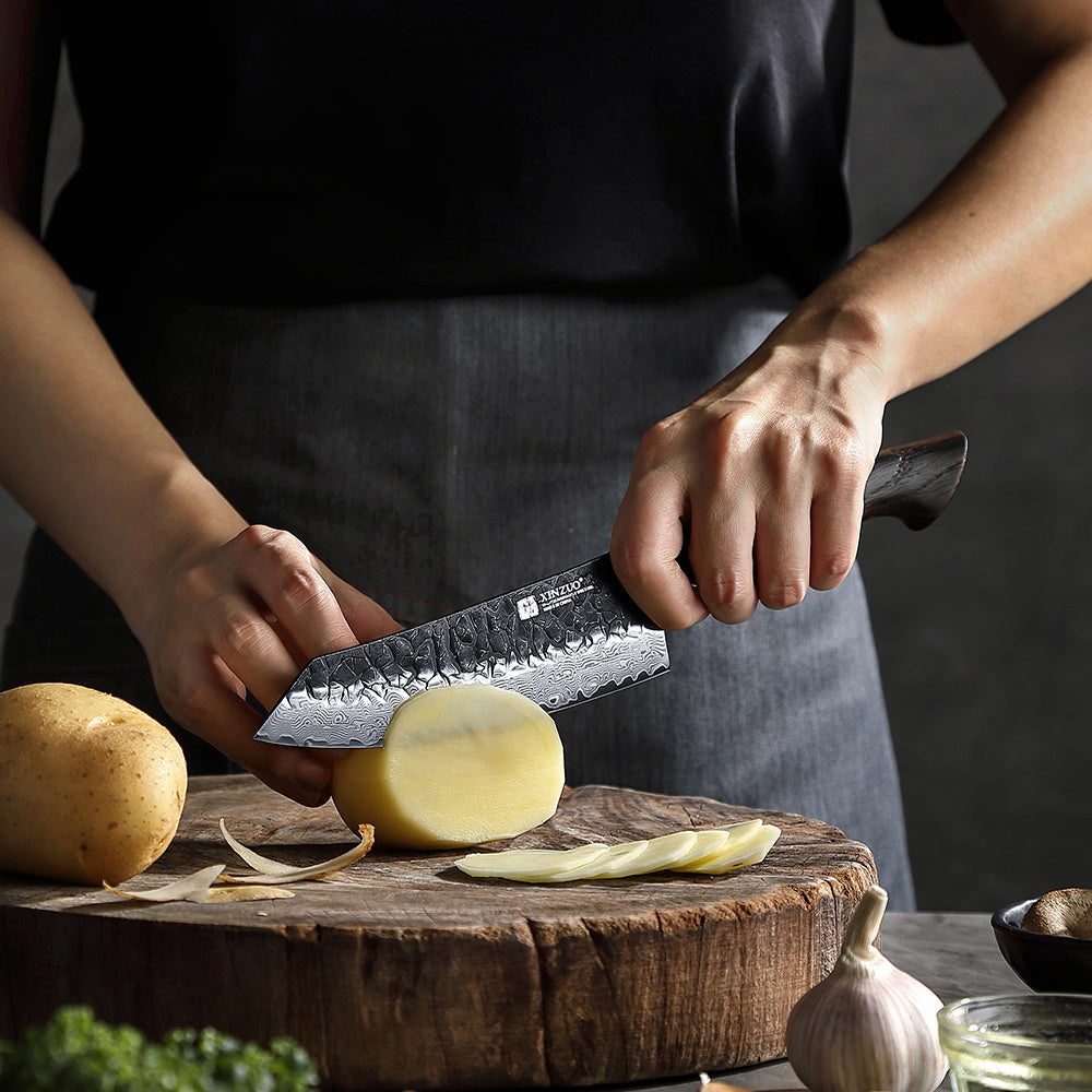 X06 Mo santokumes snijdt een aardappel op snijplank
