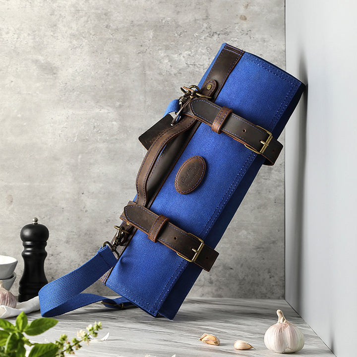 Blauwe messentas van canvas en leer, gedeeltelijk geopend met leren riemen
