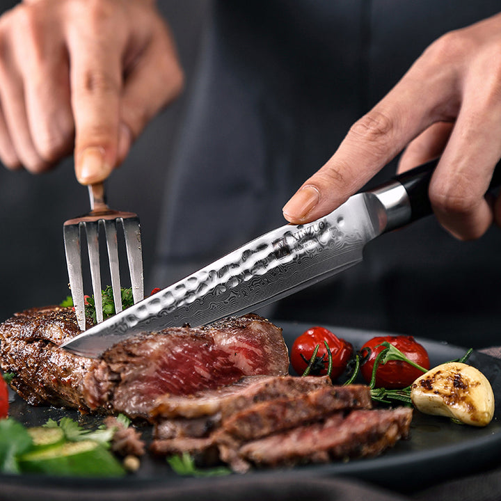 B1H He steakmes snijdt vlees met tomaten en knoflook