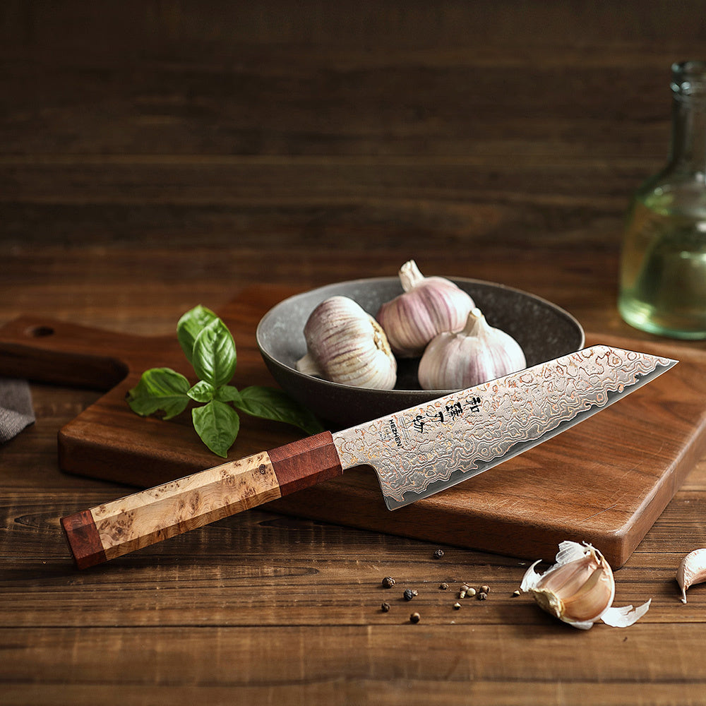 Hezhen X05C koksmes op snijplank met knoflook en basilicum op de achtergrond
