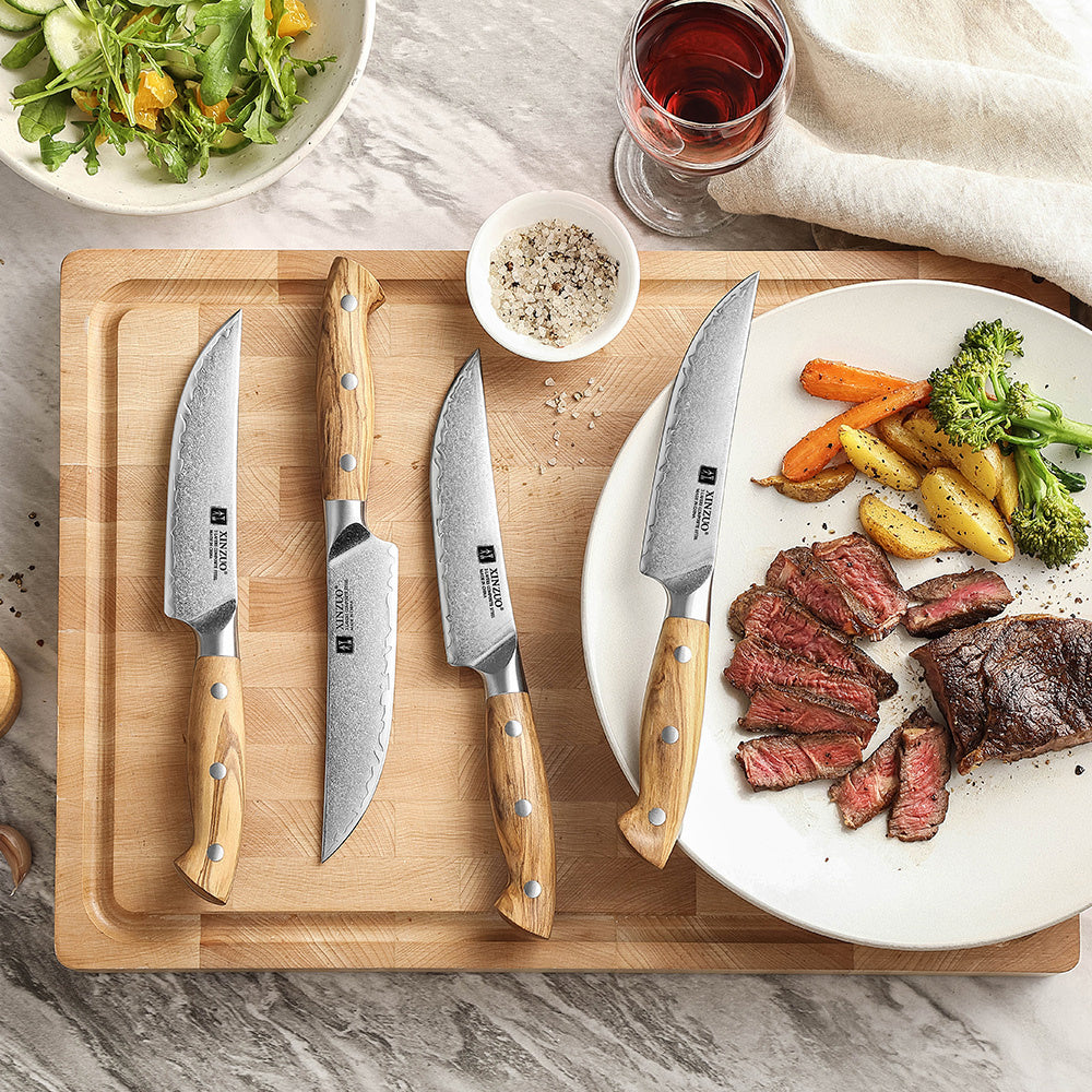 X02O Pin steakmessenset op plank, gegrild vlees op de achtergrond