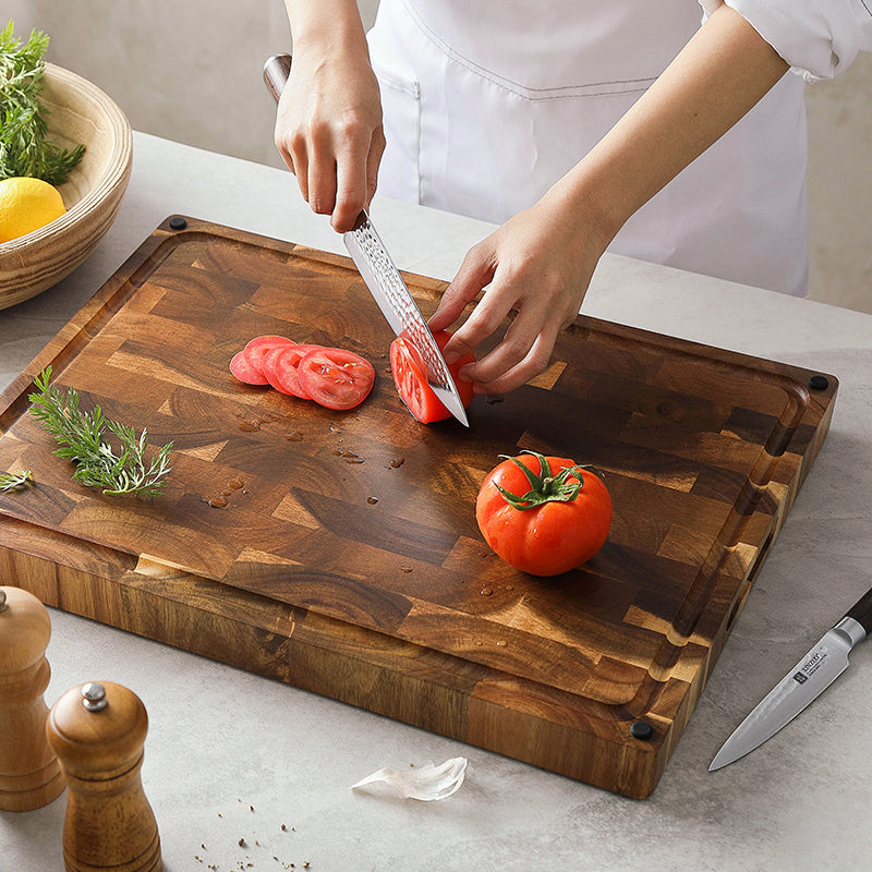 Kopshouten snijplank acacia met hand snijdt tomaten