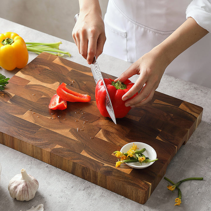 Kopshouten snijplank acacia met hand die paprika snijdt