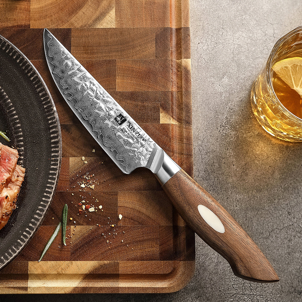 XinZuo B46W Jiang steakmes op plank naast bord met vlees