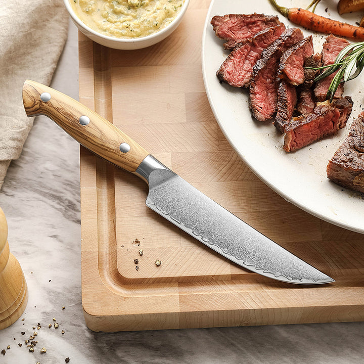 XinZuo X02O Pin steakmes op snijplank naast gesneden steak