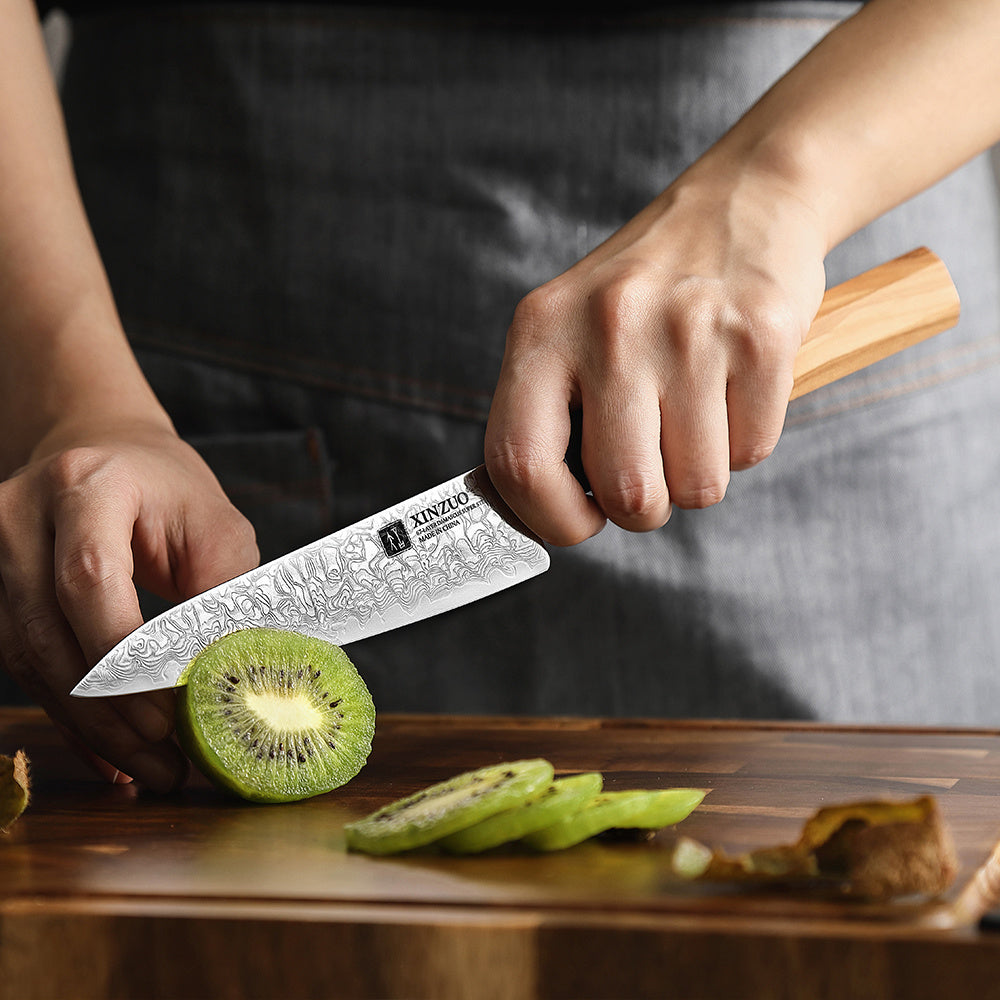 PM8O Zhen groentemes snijdt een kiwi