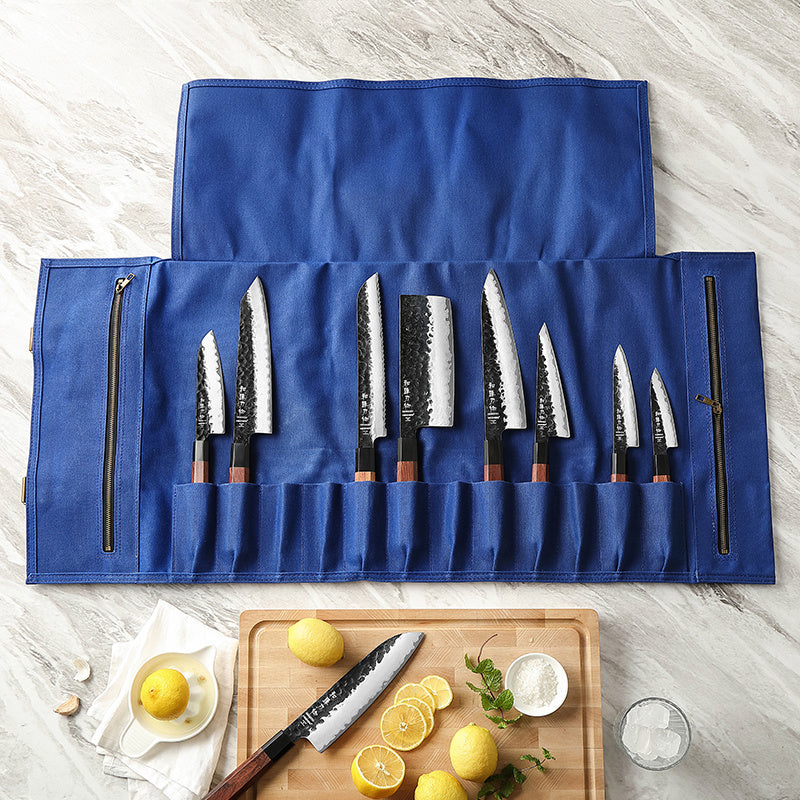 Open blauwe messentas met acht messen, op lichte ondergrond met ingrediënten