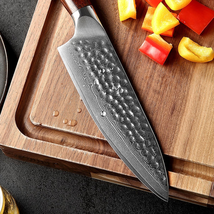 Lemmet van het B13D Yu koksmes op een plank met paprika en ananas