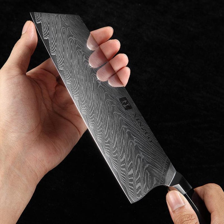 Damast lemmet van het B32 Feng cleaver in de hand